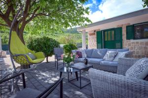 a patio with a couch and chairs and a table at Family friendly house with a swimming pool Duge Njive, Zagora - 22311 in Vrgorac
