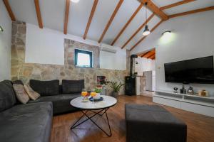 a living room with a couch and a table at Family friendly house with a swimming pool Duge Njive, Zagora - 22311 in Vrgorac