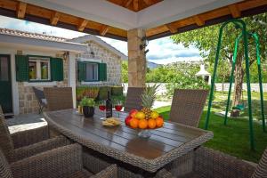 a table with fruit on it on a patio at Family friendly house with a swimming pool Duge Njive, Zagora - 22311 in Vrgorac