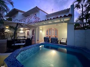 a villa with a swimming pool in front of a house at Villa 122 Sugar Hill Estate, pools, tennis, gym, 5 mins to beach in Saint James