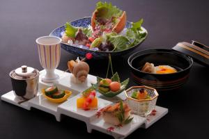 a table with a plate of food and a bowl of food at 間人温泉 炭平 in Kyotango