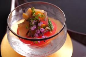 a glass cup with food in it on a table at 間人温泉 炭平 in Kyotango