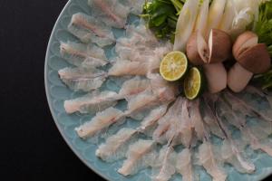 a plate of food with fish and vegetables on it at 間人温泉 炭平 in Kyotango