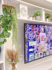 a tv on a wall with a picture of a football game at Apaisante Tropical Lodge in Tagaytay