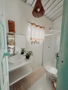a white bathroom with a sink and a toilet at Encanto Caraíva in Caraíva +56 photos