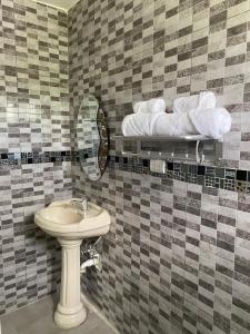 a bathroom with a sink and a mirror and towels at Missionary Guest House in Boca Chica
