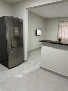 a large refrigerator in a room with a counter at Apartamento aconchegante aeroporto in Várzea Grande