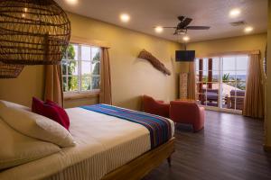 a bedroom with a bed and a living room at Mr. Tucan Hotel in West End