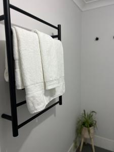 ein schwarzer Handtuchhalter mit weißen Handtüchern darauf in der Unterkunft Sussex Gem - Cozy apartment in the heart of Sussex in Sussex inlet + 25 Fotos