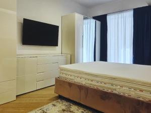 Un dormitorio con una cama y un televisor de pantalla plana. en Lazuly 2 BDR Luxury, en Varna