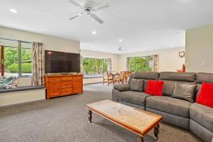 a living room with a couch and a flat screen tv at Family Hideaway in Hanmer Springs