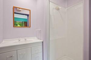 a bathroom with a sink and a shower with a mirror at Family Hideaway in Hanmer Springs +23 photos