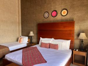 伊基托斯Casa Micaela的两张床铺,位于酒店客房,墙上挂有时钟