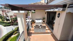 a balcony with a patio furniture and an umbrella at Las Jacarandas Penthouse with Stunning Views & Private Rooftop in Benahavís
