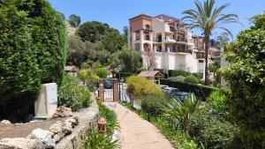 a house on the side of a hill with trees at Las Jacarandas Penthouse with Stunning Views & Private Rooftop in Benahavís