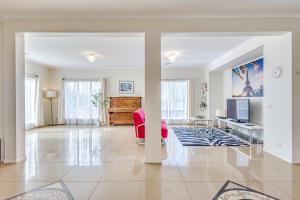 a living room with a red chair and a television at StayAU Family Home Comfort in Caroline Springs in Caroline Springs
