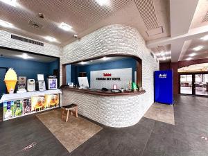 a lobby of a store with a brick wall at Tabist Tsukuba Sky Hotel in Tsukuba