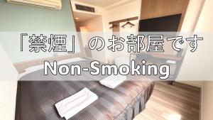 a room with a bed and a sign that says non smoking at Tabist Tsukuba Sky Hotel in Tsukuba