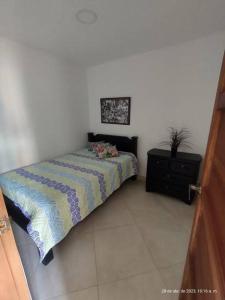 Un dormitorio con una cama y una cómoda. en Hostal casa Claudia in Jardin Antioquia, en Jardín