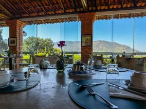 a table with plates and utensils on top at Pousada Vale do Dinossauro in São Pedro