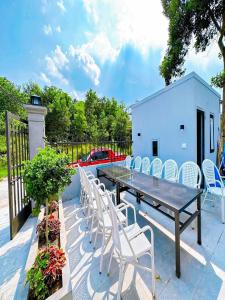 Une table à manger et des chaises sont disponibles sur la terrasse. dans l'établissement Chuỗi Villa Tuần Châu 8 Ngủ - Bể bơi riêng - sân vườn - BBQ, à Hạ Long