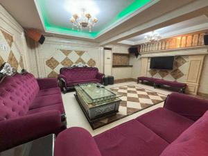 a living room with purple furniture and a tv at Lido De Paris Hotel in Manila