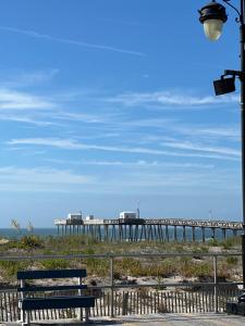 a pier on the beach with a bench and a street light at The Heart of Ocean City - Walk to beach, shopping and restaurants in Ocean City