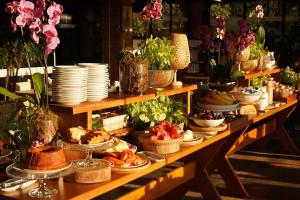 une longue table avec des assiettes et des bols de nourriture dans l'établissement Pousada Vale do Dinossauro, à São Pedro 23 autres photos