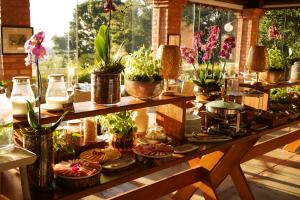 a table with potted plants and plates on it at Pousada Vale do Dinossauro in São Pedro