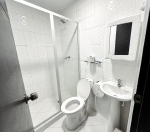 a white bathroom with a toilet and a sink at Hotel bazurto plaza in Cartagena de Indias +34 photos