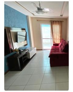 un salon avec un canapé et une télévision dans l'établissement Apartamento canto da Prainha, à Arraial do Cabo