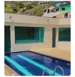 une piscine devant une maison dans l'établissement Apartamento canto da Prainha, à Arraial do Cabo