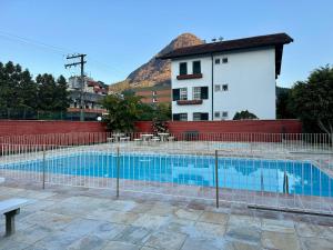 a swimming pool in front of a building at Apartamento com piscina em Olaria in Nova Friburgo