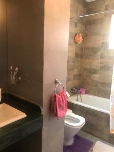 a bathroom with a toilet and a sink and a tub at PERLA SAÏDIA APPART XXL Clima IPTV Piscine Parking Jardin in Saidia 