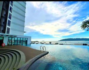 a hotel swimming pool with a view of the water at The Shore SeaView Center Kota Kinabalu Home Suites Studio in Kota Kinabalu