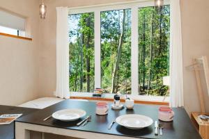 a kitchen with a table with two plates and a window at Black Spruce - Yellow Door in Whitehorse
