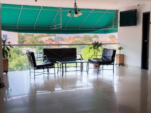 a room with chairs and a table and a large window at Hotel bazurto plaza in Cartagena de Indias