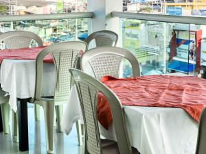 a table with white chairs and a red blanket on it at Hotel bazurto plaza in Cartagena de Indias