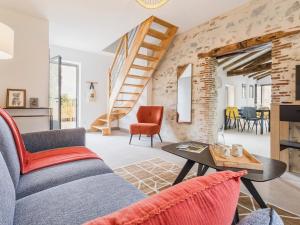 a living room with a couch and a table at Ancien corps de ferme rénové avec jardin, proche de Nantes, wifi, borne de recharge et animaux acceptés. - FR-1-306-1280 in Saint-Colomban +2 photos