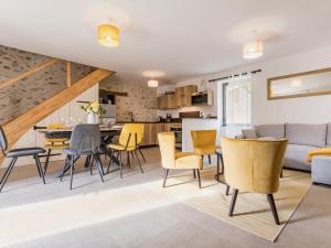 a living room and kitchen with yellow chairs and a table at Ancien corps de ferme rénové avec jardin, terrasse et recharge EV, à 24 km de Nantes - FR-1-306-1282 in Saint-Colomban