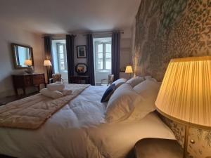 una camera da letto con un letto grande con cuscini bianchi di Chambre "Diane" avec salle d'eau privative et petit-déjeuner à Châteauroux - FR-1-591-602 a Châteauroux