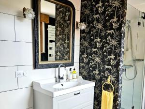 a bathroom with a sink and a mirror at Maison Trianon 1928 in Quiévrechain