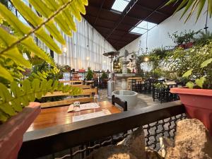 a large room with tables and chairs and plants at Casona Ancestral in Huaraz
