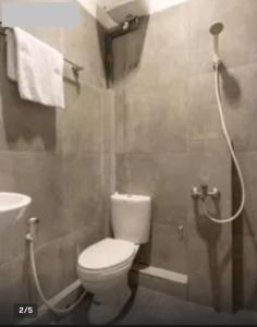 棉兰Vosstel Guest House的配有白色马桶和淋浴的浴室