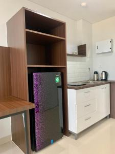 a kitchen with a black refrigerator in a cabinet at Nuvasa Bay Studio Apartment 6A10 in Nongsa +11 photos