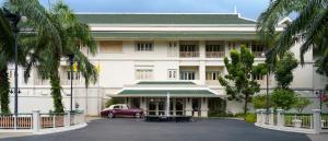 暖武里府Kalanan Riverside Resort的前面有一辆红色汽车的建筑