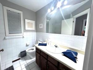 a bathroom with a sink and a toilet and a mirror at Leslie in Wasaga Beach +11 photos