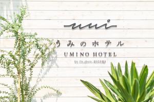 a sign on a white wall with plants at Hayama Umino Hotel in Hayama