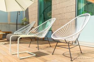 a pair of white chairs sitting on a patio at Hayama Umino Hotel in Hayama