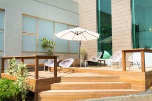 a wooden deck with chairs and an umbrella at Hayama Umino Hotel in Hayama